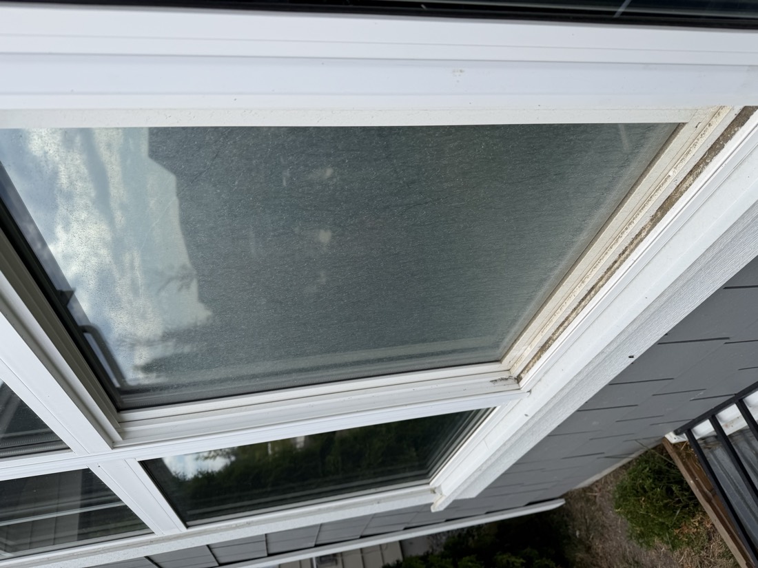 Window covered in dirt and pollen before cleaning